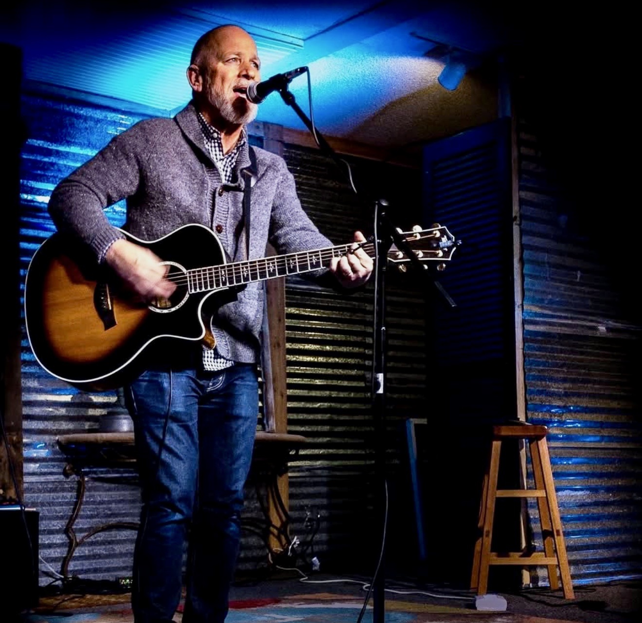 Danny Dukes performing an intimate acoustic set under blue lights